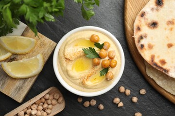 Delicious hummus with olive oil and chickpeas served on grey textured table, flat lay