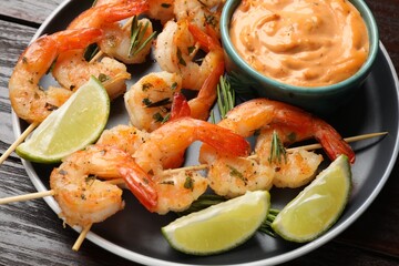 Skewers with delicious grilled shrimps served on wooden table