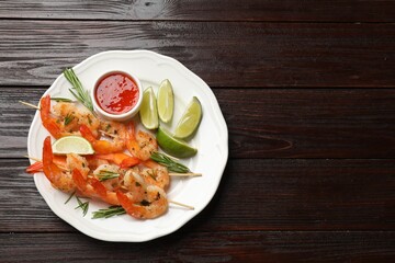 Skewers with delicious grilled shrimps served on wooden table, top view. Space for text