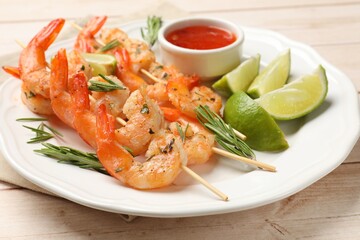 Skewers with delicious grilled shrimps served on wooden table