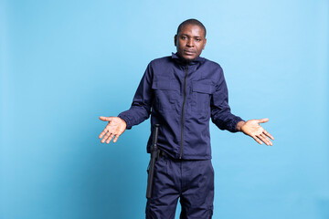 Confused uncertain bodyguard shrugging in front of the camera, raising his shoulders and presenting...