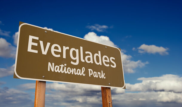 Everglades National Park (Florida) Road Sign Against Blue Sky and Clouds. - Powered by Adobe