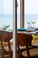 Wine glasses and table setting on a terrace overlooking the sea