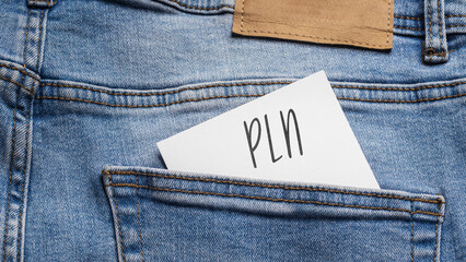 White card with a handwritten inscription "PLN", inserted into the pocket of blue pants jeasnow (selective focus)