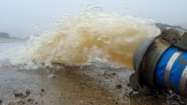 Fighting Flood After Heavy Rain as Water Pumped Out and Discharge From a Large Blue Hose