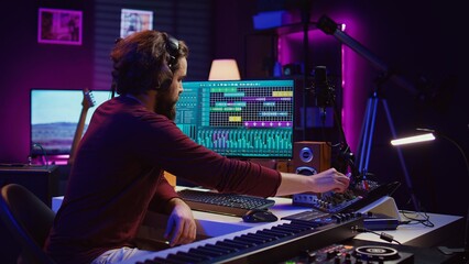 Music producer engages in post production with editing and time aligning recorded songs. Musician...