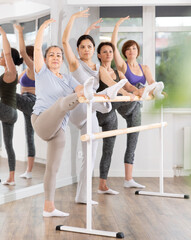 Ballet pose grand batman - women of different ages at a choreography lesson