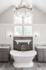 Luxurious Bathroom With Freestanding Tub, Stone Wall, Dual Sinks, And Window View