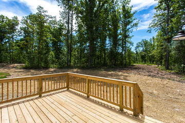 Wooden Deck Overlooking A Serene, Wooded Backyard On A Sunny Day