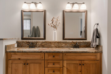 Double Sink Vanity With Granite Countertops And Wooden Cabinets In Bathroom
