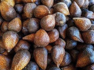 alak (Salacca zalacca) - Large amounts of snake fruit. Fresh snake fruit on the wood. Thorny Palm