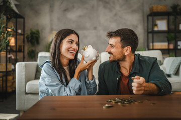 Adult couple save money coins in the piggy bank at home