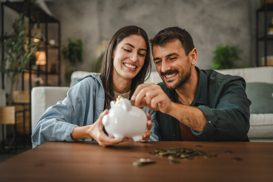 Adult couple save money coins in the piggy bank at home