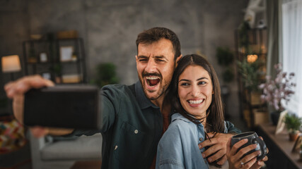 Fototapeta premium boyfriend take a self portrait of him and his girlfriend on cellphone