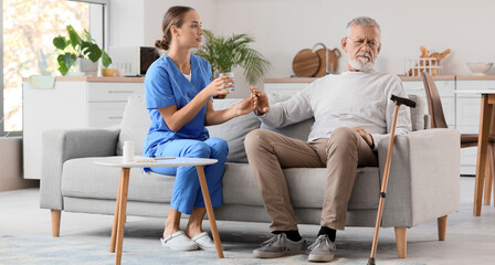 Senior man refusing to take pill from nurse at home