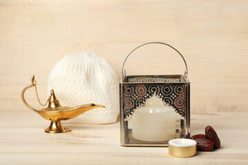 Muslim lamps with burning candles, dates and hat on light wooden background