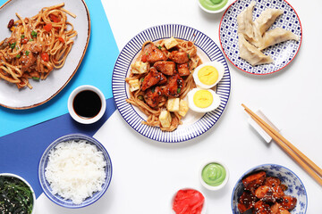 Composition with tasty Chinese dishes and chopsticks on light background