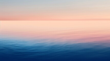 Obraz premium Calm ocean water reflecting the pink and blue colors of the sky during a beautiful sunset, creating a serene and peaceful atmosphere