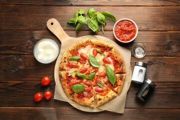 Delicious Margherita pizza and ingredients on wooden table, top view