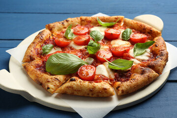 Delicious Margherita pizza on blue wooden table, closeup