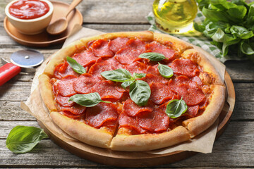 Tasty pepperoni pizza, ingredients and cutter on wooden table