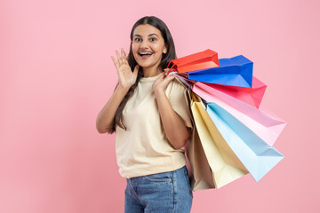Brunette woman wearing casual T-shirt and jeans holding shopping bags