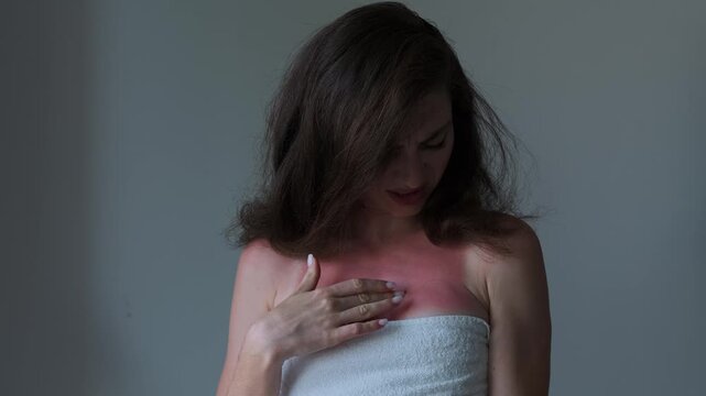 A woman with sunburned skin touching her chest, emphasizing the importance of self-care, sun protection, and sunburn relief