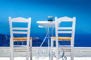 Two chairs and a small table with a wonderful view in Santorini, Greece