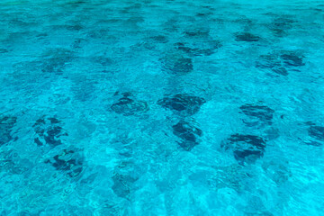 Texture of blue water under sun beams.