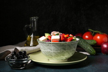 Bowl of healthy vegetable salad with napkin and ingredients on blue grunge table