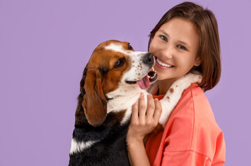 Young woman with Beagle dog on lilac background, closeup