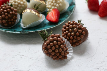 Plate with chocolate covered strawberries on white background
