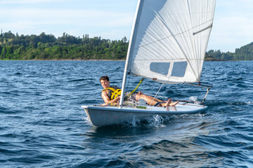View of a small Laser sailboat sailing on the lake.