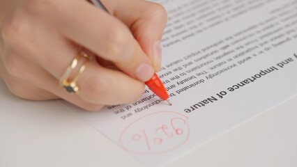 Professional school or college teacher grades a homework exam papers of students. Woman grades test...