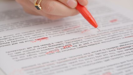 Professional school or college teacher grades a homework exam papers of students. Woman checks...