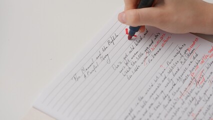 Professional school or college teacher grades a homework exam papers of students. Woman grades...