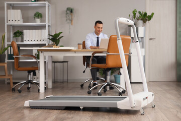 Modern treadmill of working businessman in office