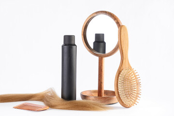 Hair spray with brush, comb, mirror and strand on white background