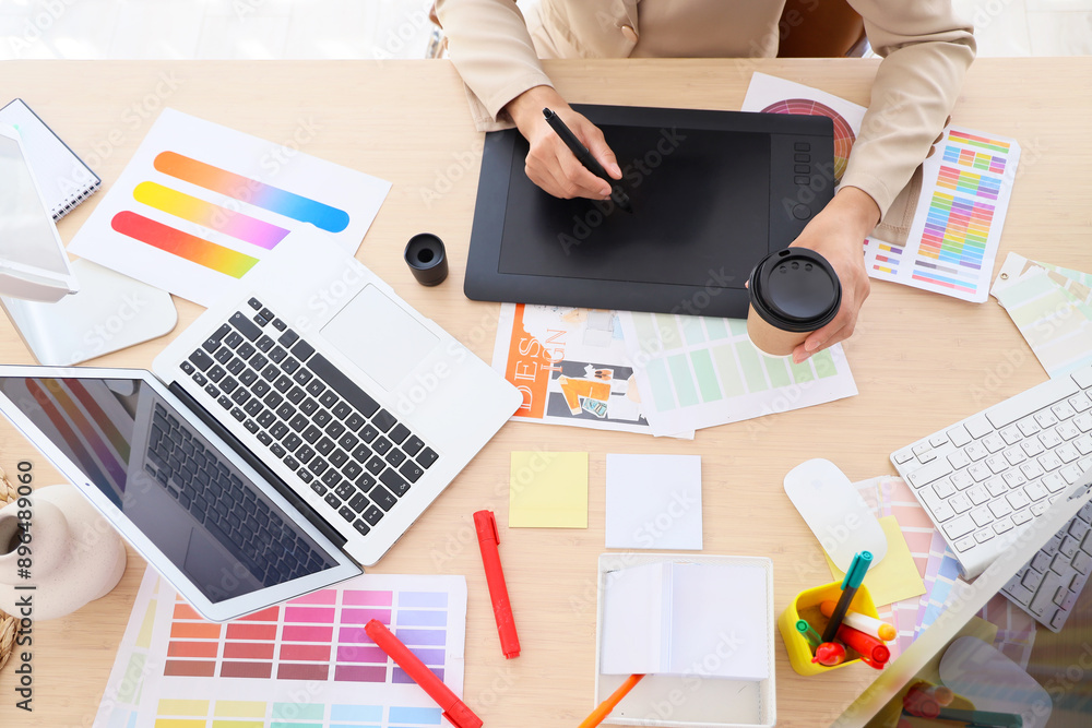 Sticker female graphic designer with tablet and coffee working at table in office, top view