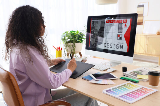 Young graphic designer with tablet working at table in office