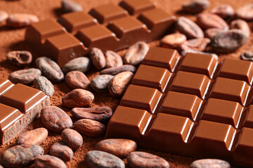 Sweet chocolate with cocoa beans on powder, closeup