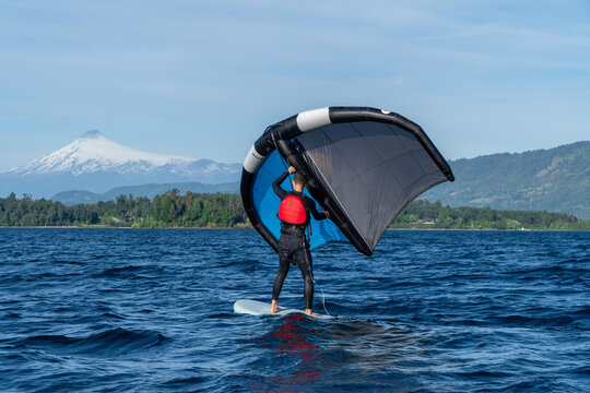 Floating wing foil enthusiast skillfully riding the waves on the lake..