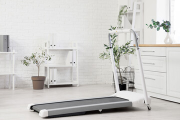 Interior of light office with treadmill and shelf units