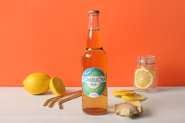 Bottle of tasty kombucha tea with lemon and ginger on white wooden table