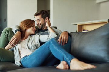 Couple, happy and relax on sofa at house for comfort, love and bonding time together with trust and...