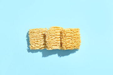 Raw instant noodles on blue background
