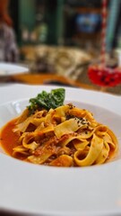 Plato de pasta en salsa roja en un restaurante elegante.