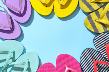 Frame made of different stylish flip-flops on blue background