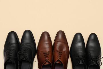 Different stylish male leather shoes on beige background