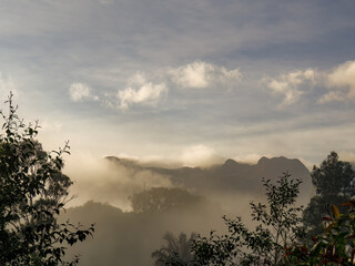 Some mist half covering the mountains and farms at sunrise, in the eastern Andean mountains of central Colombia.